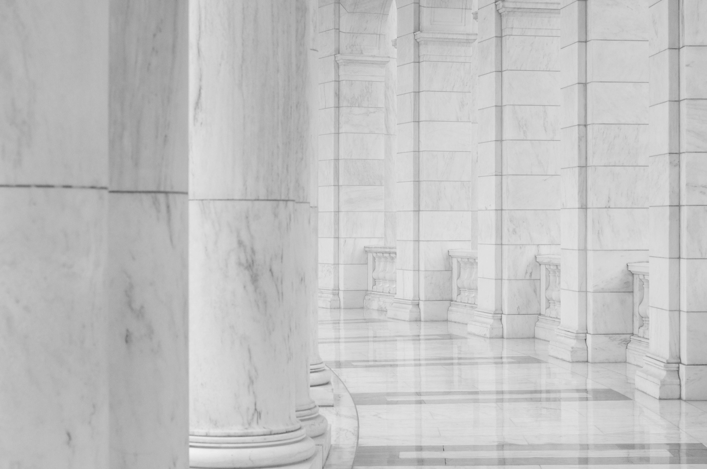A pale marble hallway between columns